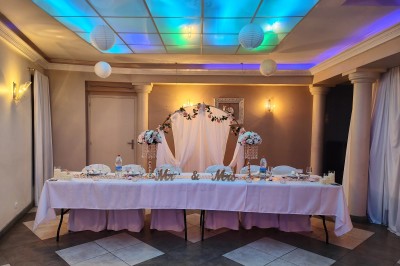 Groupe de personnes rassemblées dans une salle décorée avec des lumières et des guirlandes, lors d'une réception festive.