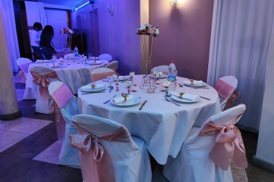 Groupe de personnes rassemblées dans une salle décorée avec des lumières et des guirlandes, lors d'une réception festive.