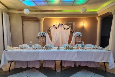 Groupe de personnes rassemblées dans une salle décorée avec des lumières et des guirlandes, lors d'une réception festive.