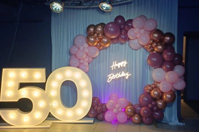 Groupe de personnes rassemblées dans une salle décorée avec des lumières et des guirlandes, lors d'une réception festive.