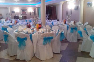 Groupe de personnes rassemblées dans une salle décorée avec des lumières et des guirlandes, lors d'une réception festive.