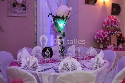 Groupe de personnes rassemblées dans une salle décorée avec des lumières et des guirlandes, lors d'une réception festive.