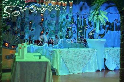 Groupe de personnes rassemblées dans une salle décorée avec des lumières et des guirlandes, lors d'une réception festive.