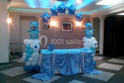 Groupe de personnes rassemblées dans une salle décorée avec des lumières et des guirlandes, lors d'une réception festive.
