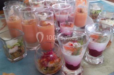 Groupe de personnes rassemblées dans une salle décorée avec des lumières et des guirlandes, lors d'une réception festive.