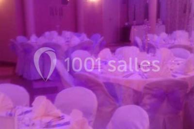 Groupe de personnes rassemblées dans une salle décorée avec des lumières et des guirlandes, lors d'une réception festive.