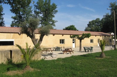 Miniature Location salle Beaucaire (Gard) - Le Fer à Cheval #2 Des enfants et des adultes préparent des poneys avec des selles dans un espace herbeux entouré d'arbres.