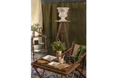 Miniature Faïencerie de Gien #2 Intérieur décoré de style vintage avec table en bois, objets anciens, plantes et vase sur un chevalet.