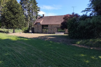 Miniature Location salle Ernée (Mayenne) - Domaine des Gautraies #2 Bâtiment en pierre avec toit en ardoise, petite terrasse en bois, tables blanches et arbres en arrière-plan.