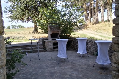 Salle de loisirs avec table de ping-pong, table de jeu blanche, cible de fléchettes et murs en bois et pierre.