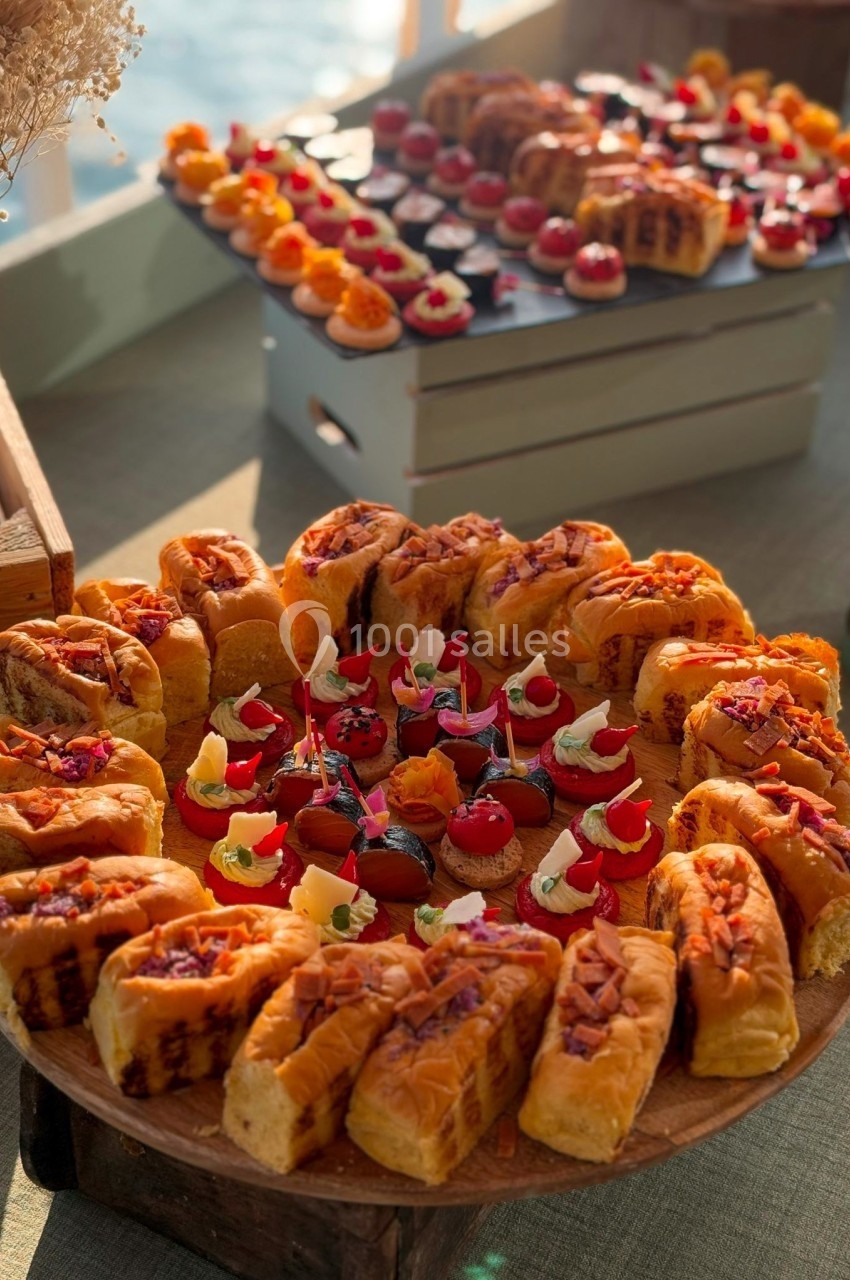 Plateau de viennoiseries et de petits desserts colorés présentés sur une table lors d'un buffet.