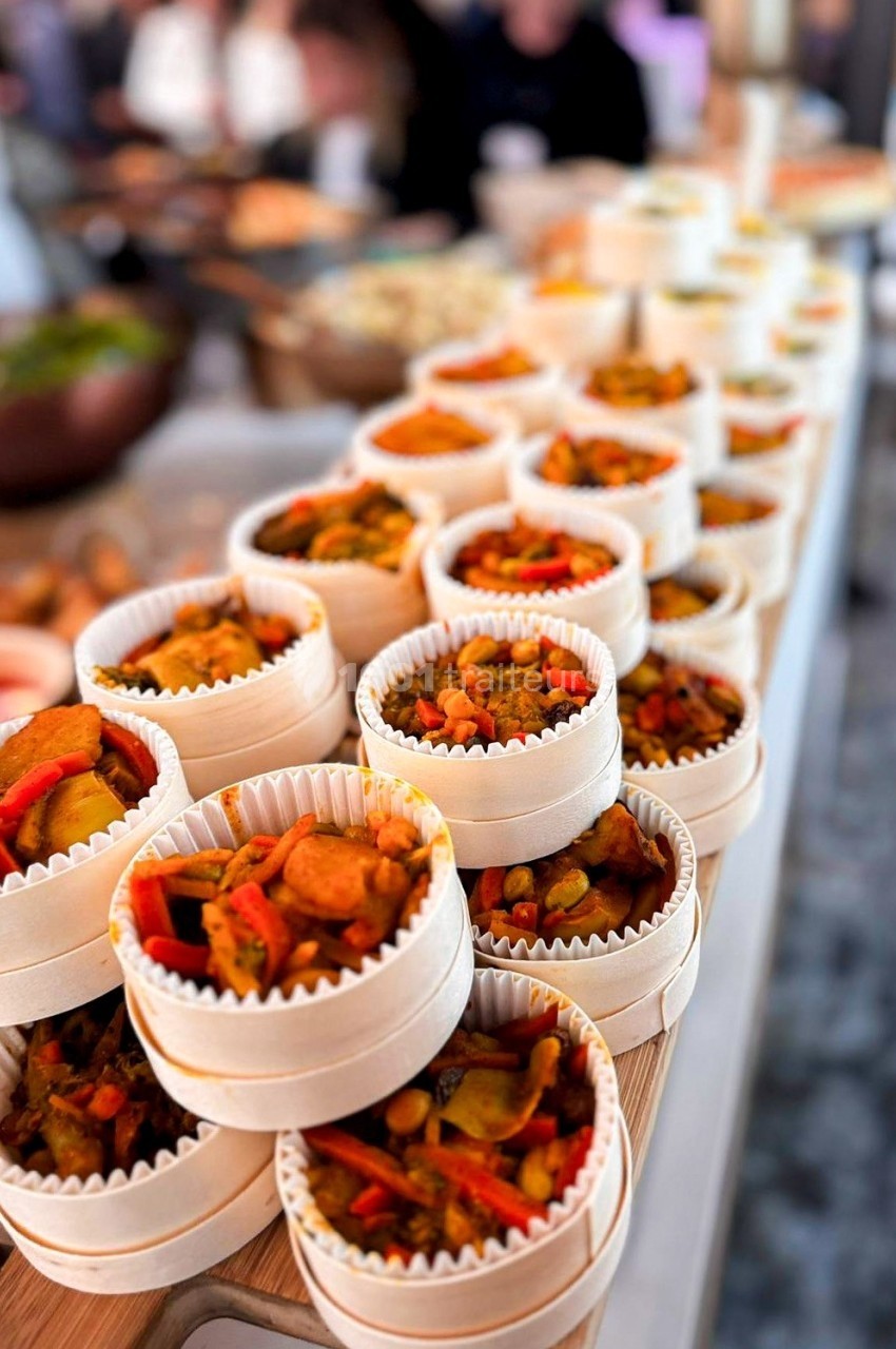 Petits plats en barquettes en bois contenant un mélange de légumes colorés, disposés en rangées sur une table.