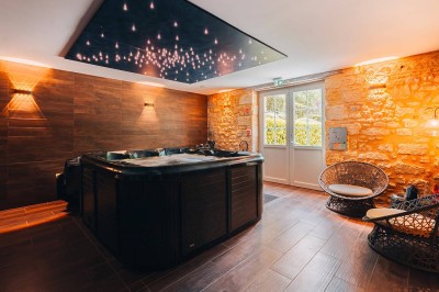 Chambre lumineuse avec lit double, bureau, télévision, grande fenêtre et salle de bain attenante visible.