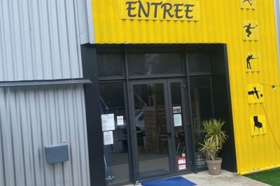 Miniature Location salle Nozay (Loire-Atlantique) - Le Multiball #14 Entrée d'un bâtiment avec une façade jaune et grise, signalée par un panneau ’ENTREE’ et des pictogrammes sportifs.