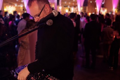 Miniature DJ Montpellier (Hérault) - Essentiel Vocal #6 Un DJ mixant de la musique lors d'une soirée festive avec des invités dans une salle éclairée par des lumières colorées.