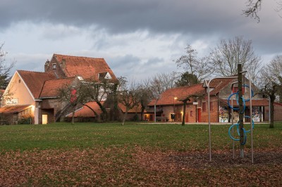Miniature Location salle Linkebeek (Brabant flamand) - Ferme Holleken Hoeve #6 Façade d'une maison orange à trois étages avec toit en tuiles, entourée de bâtiments en briques et d'une cour pavée.