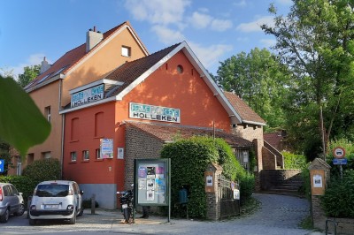 Miniature Location salle Linkebeek (Brabant flamand) - Ferme Holleken Hoeve #7 Façade d'une maison orange à trois étages avec toit en tuiles, entourée de bâtiments en briques et d'une cour pavée.