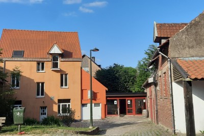 Miniature Location salle Linkebeek (Brabant flamand) - Ferme Holleken Hoeve #8 Façade d'une maison orange à trois étages avec toit en tuiles, entourée de bâtiments en briques et d'une cour pavée.