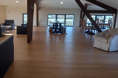 Salle moderne avec cuves en acier inoxydable alignées pour la production de vin, éclairée par des luminaires circulaires.