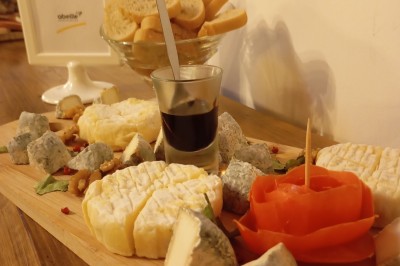 Table dressée avec verre, fourchette et serviette dans un restaurant rustique avec murs en pierre et menu en arrière-plan.