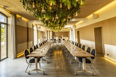 Douche moderne avec paroi vitrée, rideau à motifs noirs, sol en bois et porte blanche adjacente.