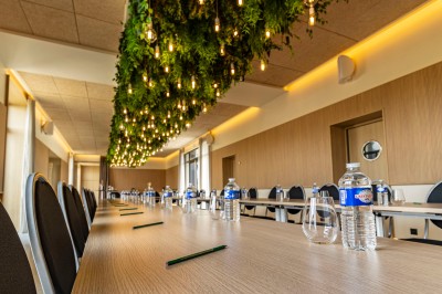 Douche moderne avec paroi vitrée, rideau à motifs noirs, sol en bois et porte blanche adjacente.