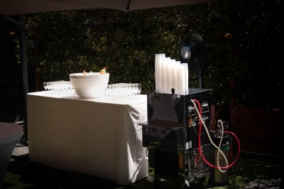 Miniature Location salle Toulouse (Haute-Garonne) - La Cantine d'Horace #17 Brasero allumé avec des flammes vives, placé sur une terrasse extérieure près d'arbustes et de parasols.