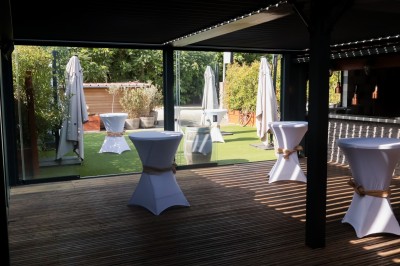 Miniature Location salle Toulouse (Haute-Garonne) - La Cantine d'Horace #4 Brasero allumé avec des flammes vives, placé sur une terrasse extérieure près d'arbustes et de parasols.