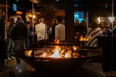 Miniature Location salle Toulouse (Haute-Garonne) - La Cantine d'Horace #10 Brasero allumé avec des flammes vives, placé sur une terrasse extérieure près d'arbustes et de parasols.