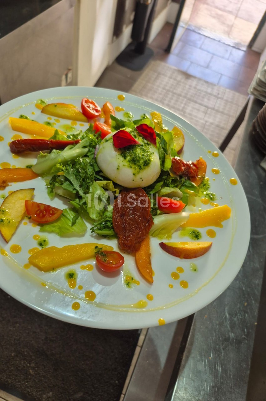 Assiette gastronomique composée d'une œuf mollet, verdures, légumes rôtis et perles de sauce sur fond blanc.