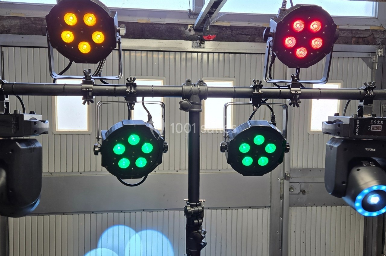 Projecteurs LED colorés et spots montés sur une structure métallique dans un espace de type garage.