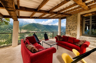 Miniature Location salle Entrevaux (Alpes-de-Haute-Provence) - Domaine de Glandève #12 Un couple en tenue de mariage regarde un paysage montagneux au coucher du soleil depuis une terrasse en pierre.