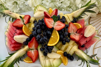 Buffet en extérieur avec une variété de desserts et amuse-bouches disposés sur des tables alignées.