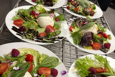 Buffet en extérieur avec une variété de desserts et amuse-bouches disposés sur des tables alignées.