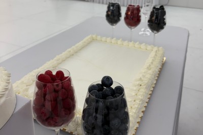 Buffet en extérieur avec une variété de desserts et amuse-bouches disposés sur des tables alignées.