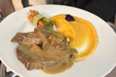 Buffet en extérieur avec une variété de desserts et amuse-bouches disposés sur des tables alignées.