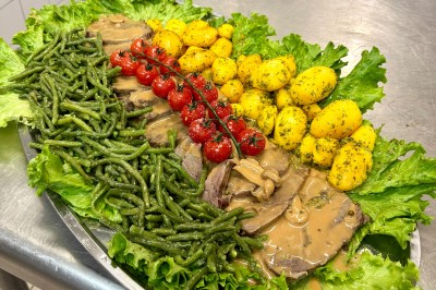 Buffet en extérieur avec une variété de desserts et amuse-bouches disposés sur des tables alignées.