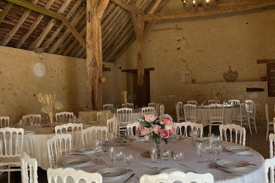 Miniature Salle pivoine Chemin en sable clair bordé de végétation, menant à un paysage de champs et de forêt sous un ciel bleu.