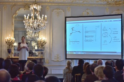 Miniature Karine Baillet Organisation #10 Groupe de personnes s'étirant sur une plage de sable face à la mer sous un ciel nuageux.