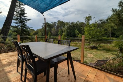 Miniature Location salle Saint-Guyomard (Morbihan) - Domaine de Ker Léon #45 Espace extérieur avec tables hautes noires sur une pelouse, devant un bâtiment vitré et un comptoir en bois.