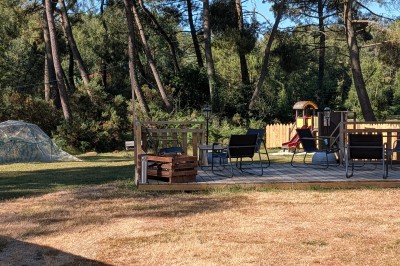 Miniature Location salle Saint-Guyomard (Morbihan) - Domaine de Ker Léon #58 Espace extérieur avec tables hautes noires sur une pelouse, devant un bâtiment vitré et un comptoir en bois.