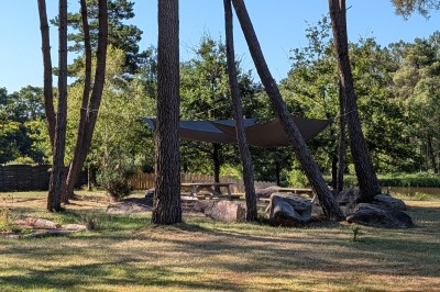 Miniature Location salle Saint-Guyomard (Morbihan) - Domaine de Ker Léon #62 Espace extérieur avec tables hautes noires sur une pelouse, devant un bâtiment vitré et un comptoir en bois.