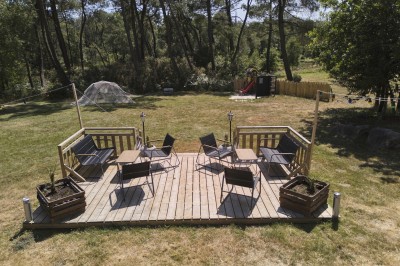Miniature Location salle Saint-Guyomard (Morbihan) - Domaine de Ker Léon #77 Espace extérieur avec tables hautes noires sur une pelouse, devant un bâtiment vitré et un comptoir en bois.