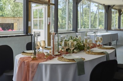 Miniature Location salle Saint-Guyomard (Morbihan) - Domaine de Ker Léon #78 Espace extérieur avec tables hautes noires sur une pelouse, devant un bâtiment vitré et un comptoir en bois.