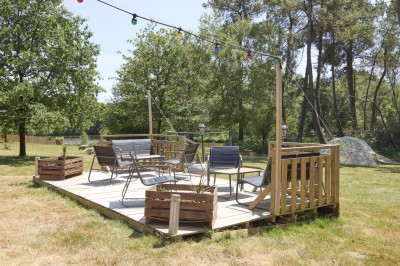Miniature Location salle Saint-Guyomard (Morbihan) - Domaine de Ker Léon #90 Espace extérieur avec tables hautes noires sur une pelouse, devant un bâtiment vitré et un comptoir en bois.