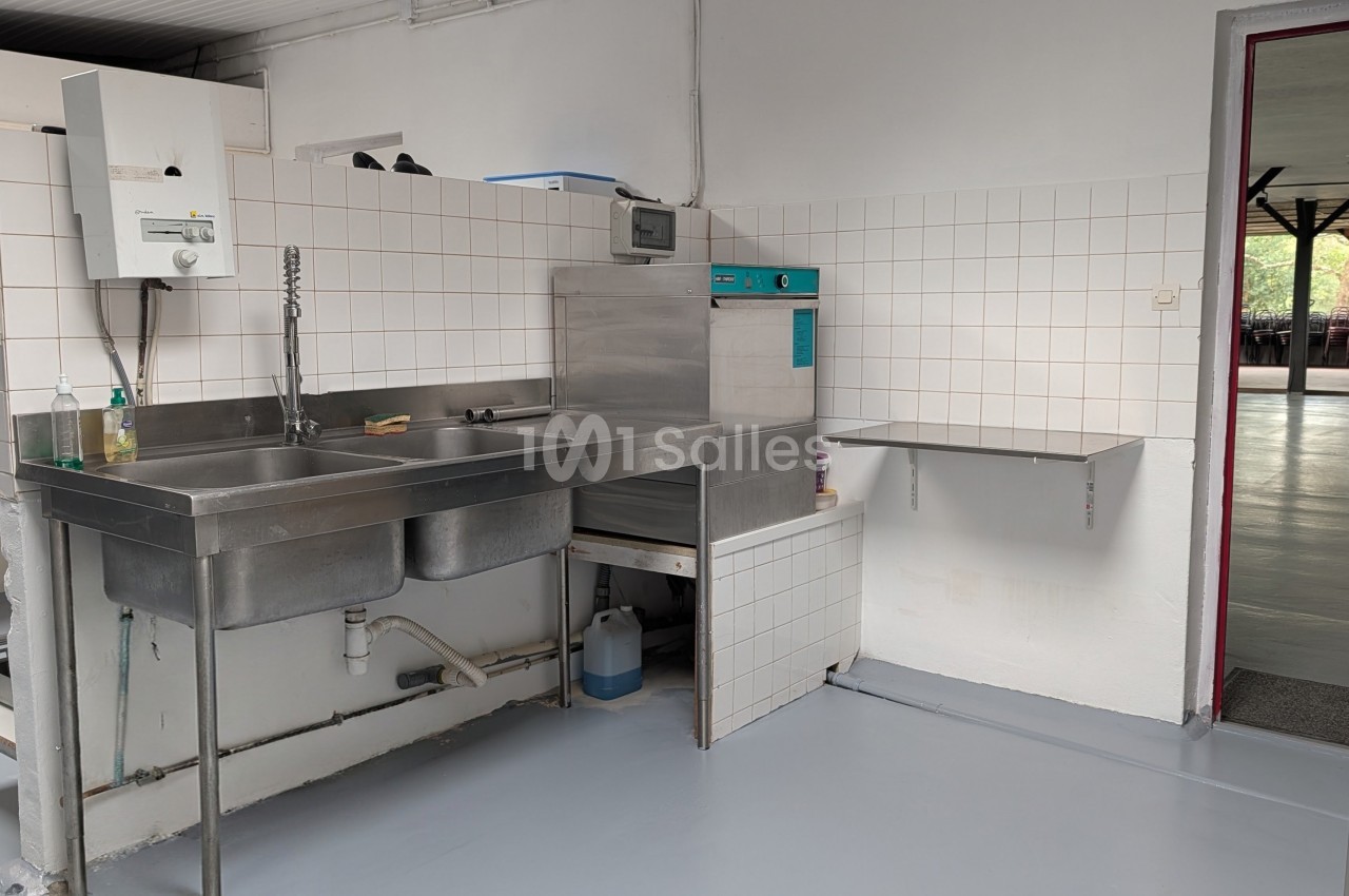 Cuisine professionnelle équipée d'un évier double, d'une plonge et d'appareils inox - vue générale.