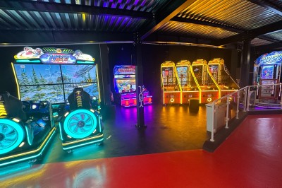 Intérieur d'une boutique avec comptoirs de vente proposant glaces, boissons et snacks, éclairée par des lumières modernes.
