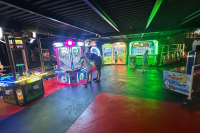 Intérieur d'une boutique avec comptoirs de vente proposant glaces, boissons et snacks, éclairée par des lumières modernes.