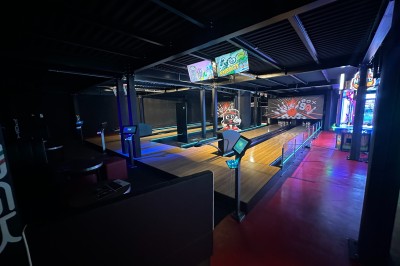 Intérieur d'une boutique avec comptoirs de vente proposant glaces, boissons et snacks, éclairée par des lumières modernes.