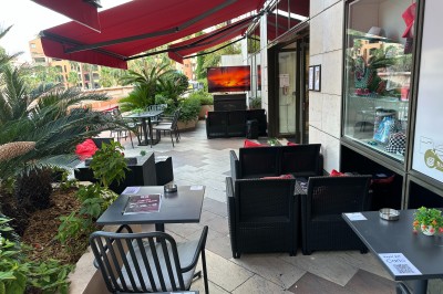 Intérieur d'une boutique avec comptoirs de vente proposant glaces, boissons et snacks, éclairée par des lumières modernes.